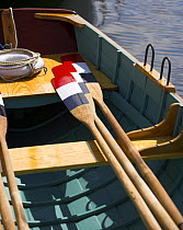 Red, white and blue oar blades and a lifering on the deck of a boat at the Newport Wooden Boat Show, Rhode Island.