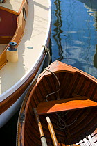Wooden tender tied up alongside a wooden yacht at the Newport Wooden Boat Show, Rhode Island.