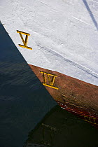Water-line markers in Roman numerals on the hull of a wooden boat at the Newport Wooden Boat Show, Rhode Island.