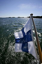Finish ensign flying while sailing in the Finnish Archipelago, Finland.