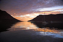 Sailboats and motorboats anchored between the mountains at sunset in Caleta Partida, Mexico. 2006.
