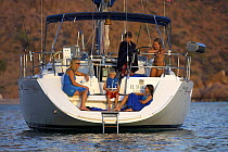 After swimming, a family enjoying an afternoon on their anchored sailboat while cruising in Caleta El Candelero, Mexico. 2006.