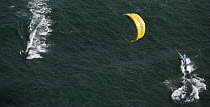 Kite boarding alongside a catamaran during the Hobie 16 Nationals, Narragansett, Rhode Island, USA.