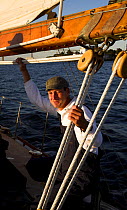 The Captain during an evening charter onboard 12m classic yacht "Gleam" sailing in Narragansett Bay off Newport, Rhode Island, USA, 2006.