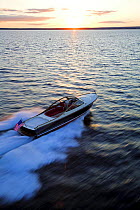 Hinckley T38R speedboat travelling fast towards the sunset, Rhode Island, USA.