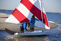 Standing in shallow water beside a Sunfish ready for sailing in Charleston, South Carolina, USA.