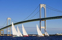 A fleet of 12m yachts racing under Newport Bridge, Rhode Island, USA. October 2006.