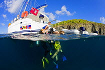 People returning to a catamaran after scuba diving, British Virgin Islands, Caribbean, December, 2006.