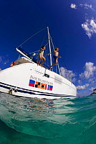 Two children jumping from a catamaran into the sea, British Virgin Islands, Caribbean, December, 2006.