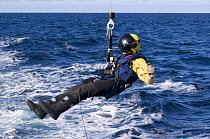 Winchman being lowered from a helicopter during a training excercise on the North Sea.