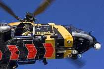 Winchman preparing to be lowered from a helicopter during a training excercise on the North Sea.
