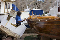 Man varnishing a boat, Dubrovnik, Croatia.
