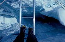 Crossing a crevasse ladder in the Khumbu Icefall on Mount Everest Nepal. Model released. Freeze Frame book plate page 143.