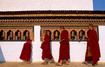 Monks turning prayer wheel Dzongchung temple Punakha Dzong Central Bhutan