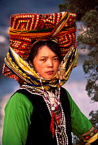 Black Yi single woman wears traditional bright colours Lijiang county, Yunnan, China