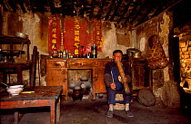 Han man smoking traditional pipe in home Shilin, Yunnan, China