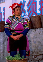 Yi woman with child Yuanyang market, Honge, Yunnan, China ethnic minority group