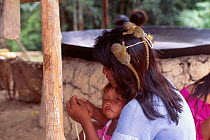 Tikuna woman with Pygmy marmoset twins on head {Cebuella pygmaea} Brazil Alto Solimoes