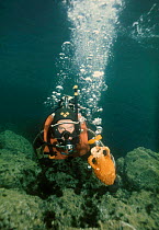 Diver carrying amphora up from seabed. Mediterranean